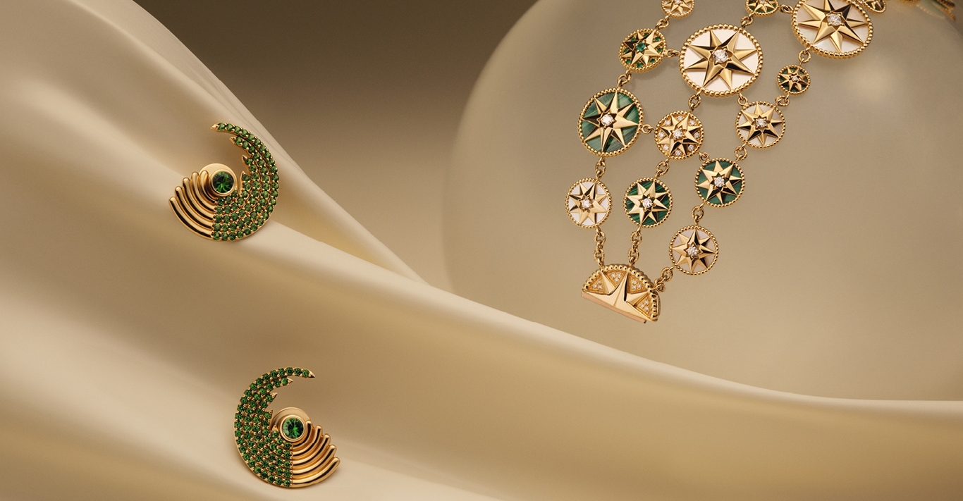 Large Zouk earrings in 18k yellow gold with tsavorites pictured alongside oaillerie Rose des Vents bracelet in pink and yellow gold, diamonds, emeralds and gemstones