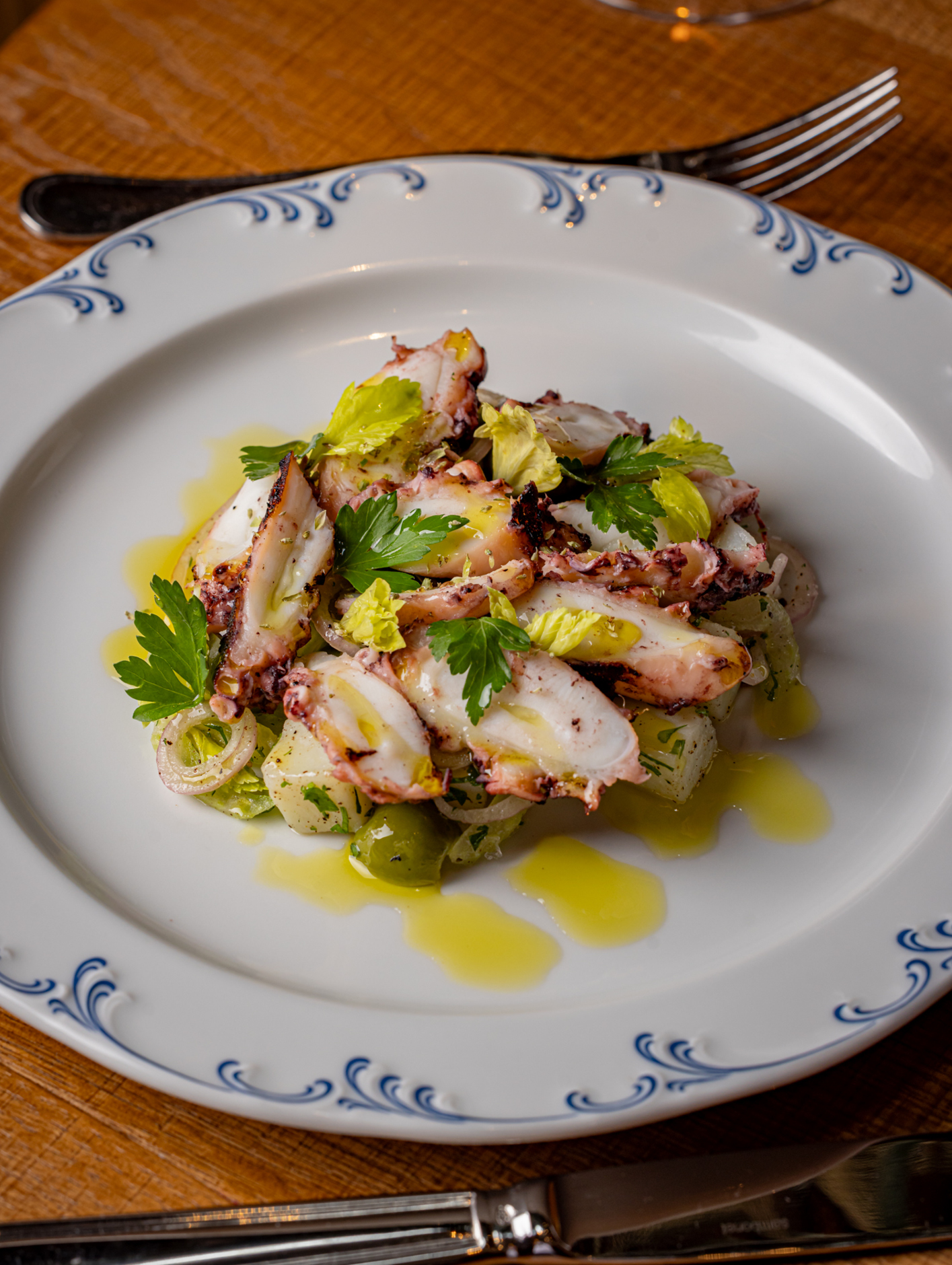 Grilled octopus on a bed of potatoes, celery, black olives and cipollini onions