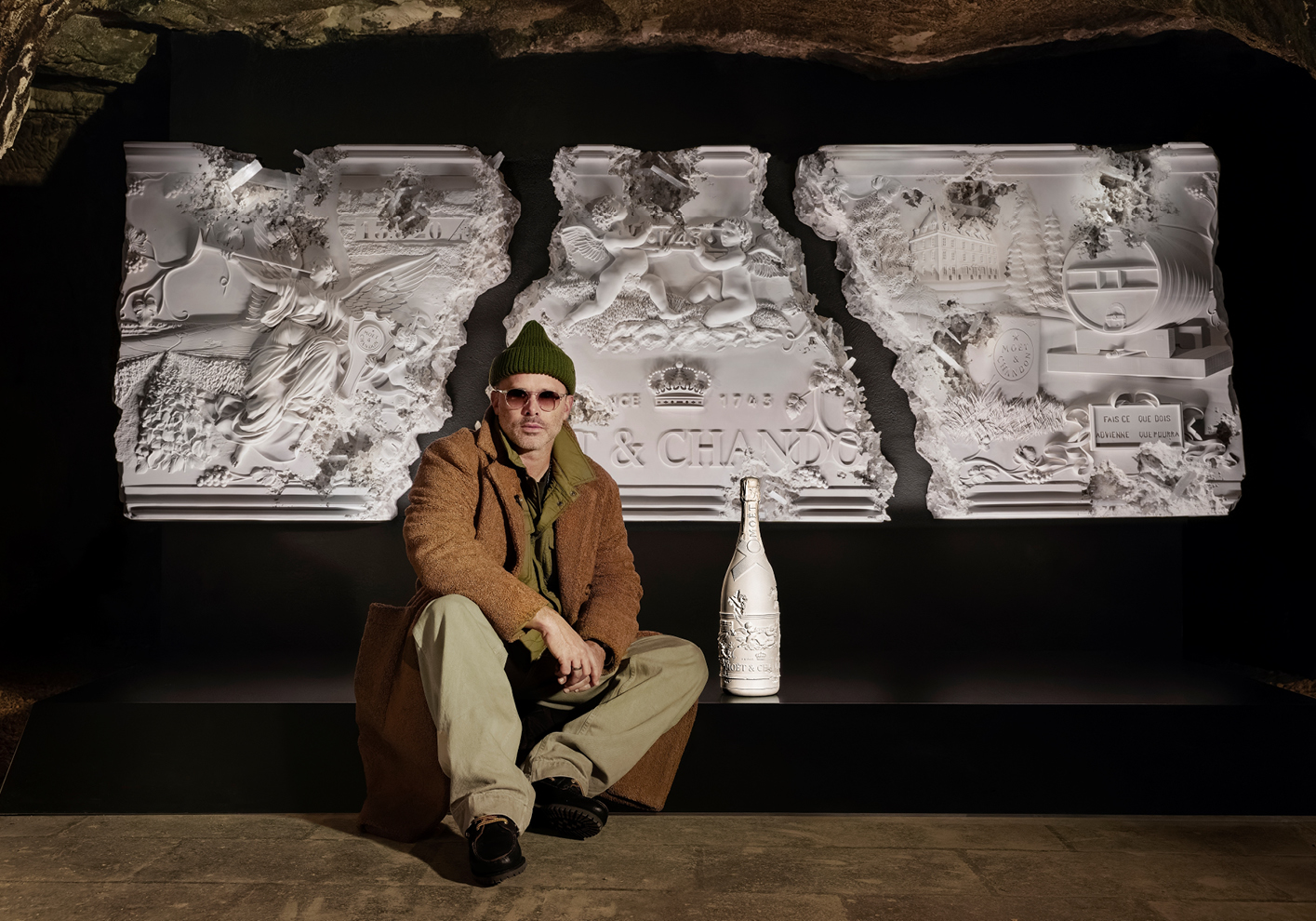 Daniel Arsham sits in front of his wall-mounted shallow relief, conveying the legacy of Moët & Chandon