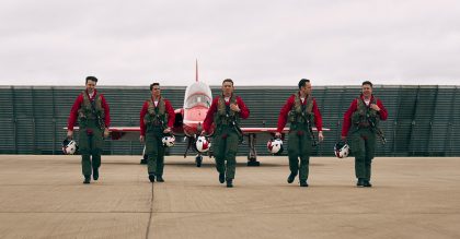 Five Red Arrows team members walking in front of a plane