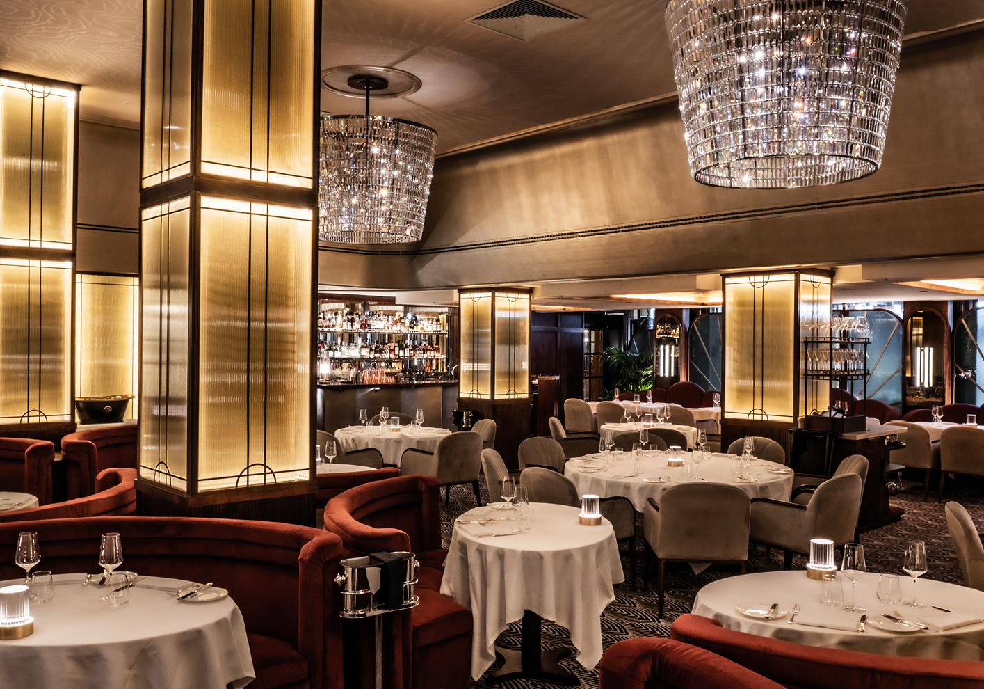 The Interior at the Savoy Grill, formed of elements including velvet booths, silk-lined walls and metallic and glass accents