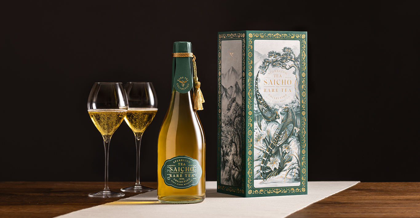 Two glasses filled with Sancho's Sixty Stone Mountain sparkling tea alongside the highly decorated box